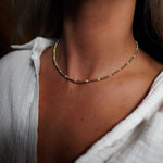 INDIVIJWL Gold and Pearl Beaded Choker Necklace shown on a model, featuring 24k gold-filled 3mm spacer beads and delicate shell pearls. This 16-inch tarnish-resistant choker is designed to enhance natural beauty and symbolize emotional balance.