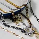 INDIVIJWL jewelry styled with multiple gold and silver chains, showcasing the blue evil eye charm with a cubic zirconia gold-filled removable bail. An elegant, protective accessory for layering necklaces.